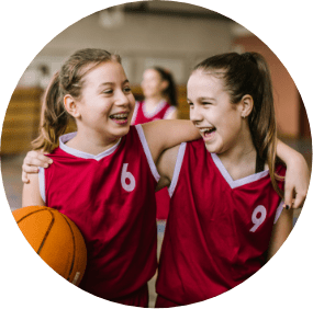Two young girls playing basketball